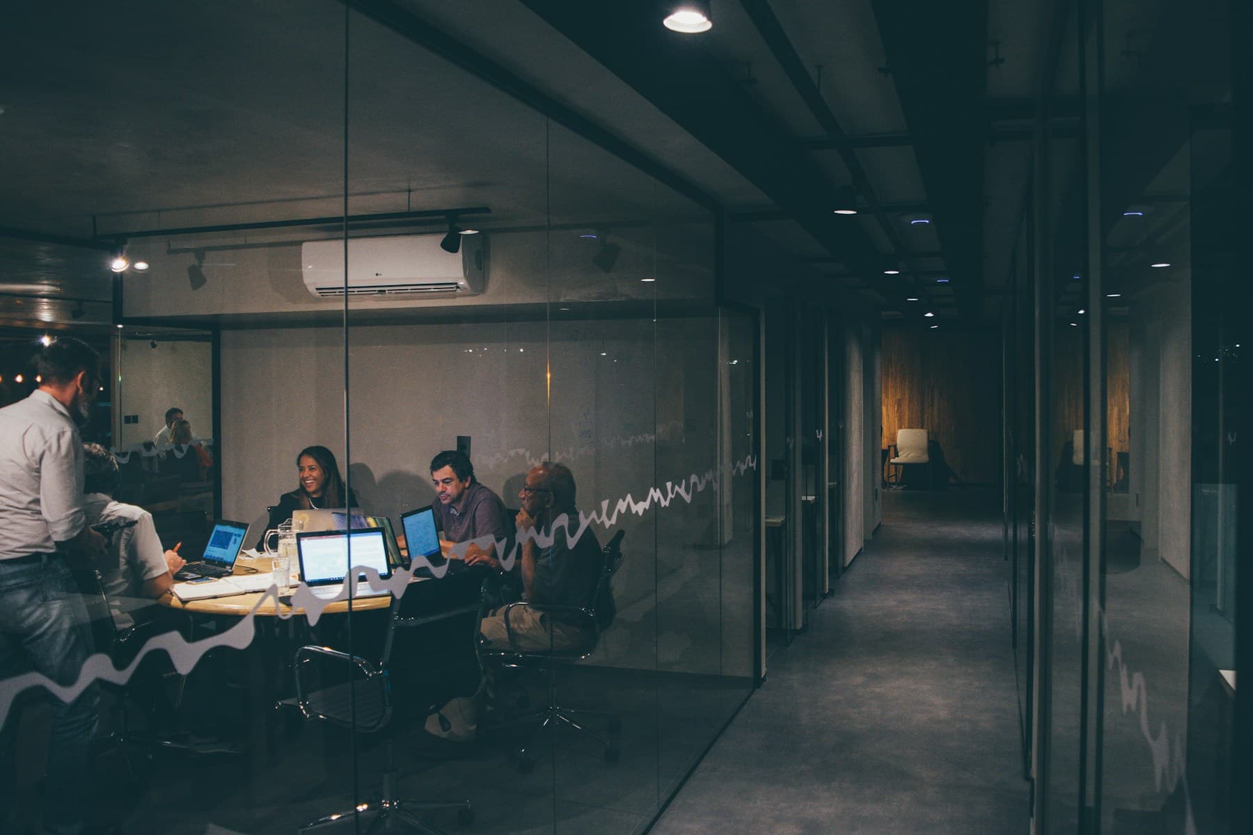 People working together around laptops in a meeting room.